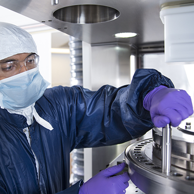 Male in lab wearing mask and protective blue gear